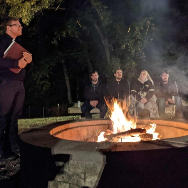 Young adults talk synod around a bonfire