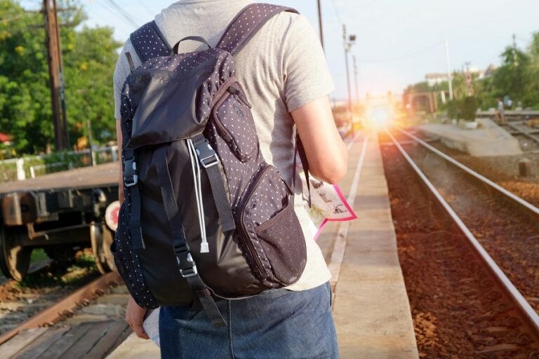 person with a backpack shown from behind with sunburst ahead