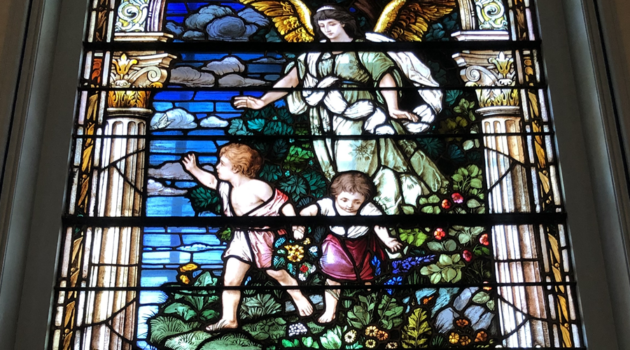 Stained glass window shows guardian angel with boy and girl