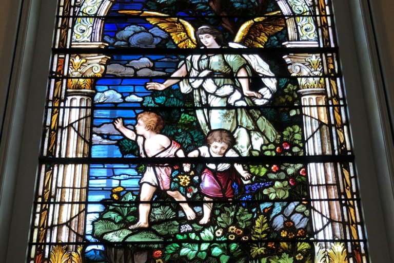 Stained glass window shows guardian angel with boy and girl