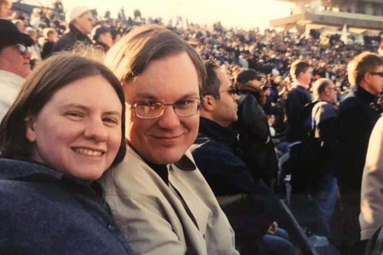 My brother-in-law and sister smiling for the camera at a football game in a stadium in New Haven Connectict