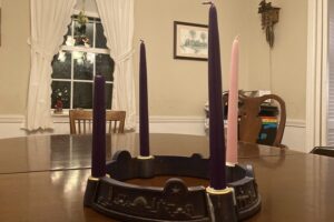 Four unlit candles stand in an Advent wreath on a table