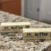 Two sticks of butter sit on a kitchen counter