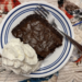 Brownie on a plate with whipped cream a fork