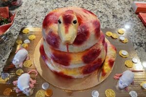 A red and gold cake in the shape of a coiled snake