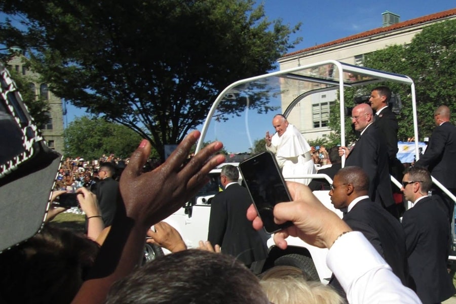 Pope Francis rides by a crowd outside Catholic University in 2015