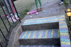steps and a sidewalk decorated in colored chalk by children