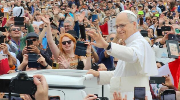 A smiling Pope Leo waves to a crowd in St. Peter's Square