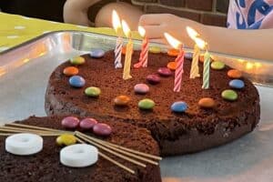 Six lit candles on a chocolate birthday cake