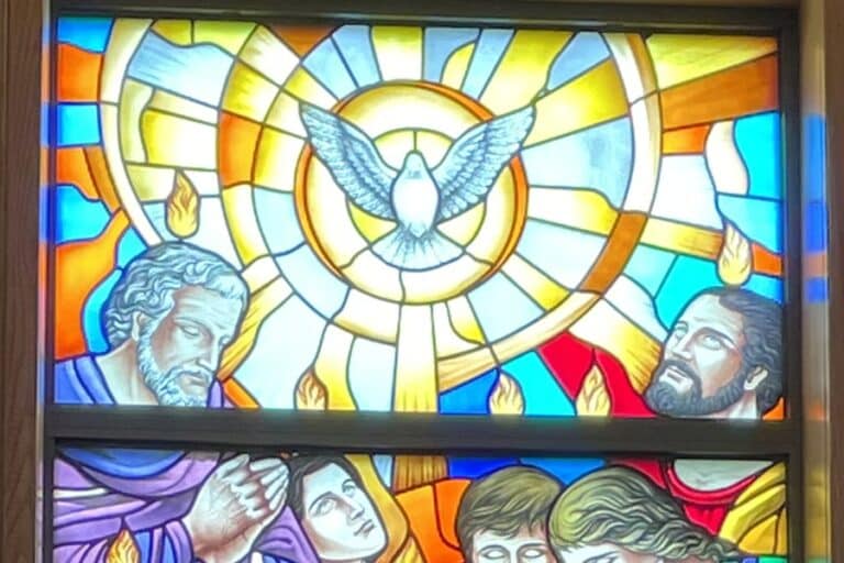 Stained glass window depicting a dove and some of the apostles with flames over their heads