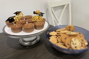 Cupcakes with 2025 graduation toothpicks in them and a bowl of cookies