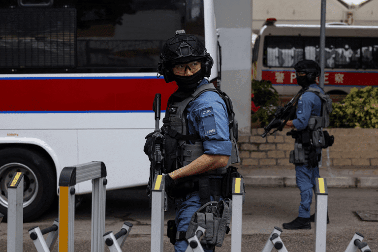 Police officers stand guard outside Jimmy Lai trial