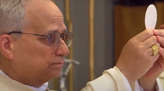 Pope Leo holds the host up in both hands during the consecration