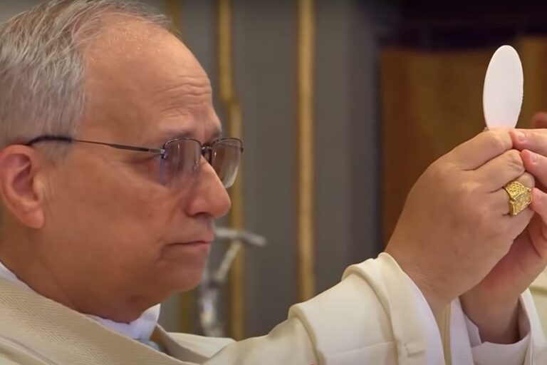 Pope Leo holds the host up in both hands during the consecration