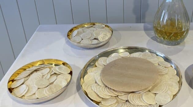 hosts sit on plates ready for communion at church