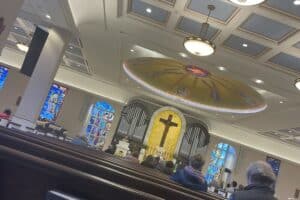View of a church with a dome and a crucifix and pews