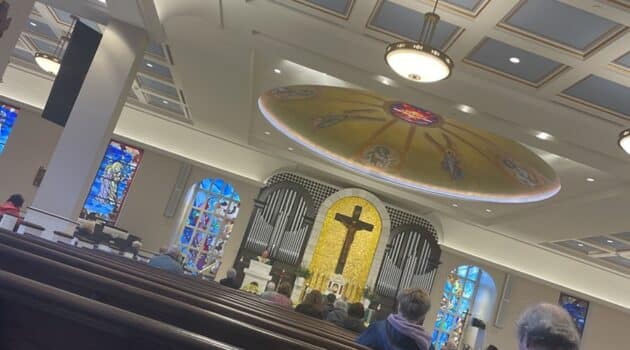 View of a church with a dome and a crucifix and pews
