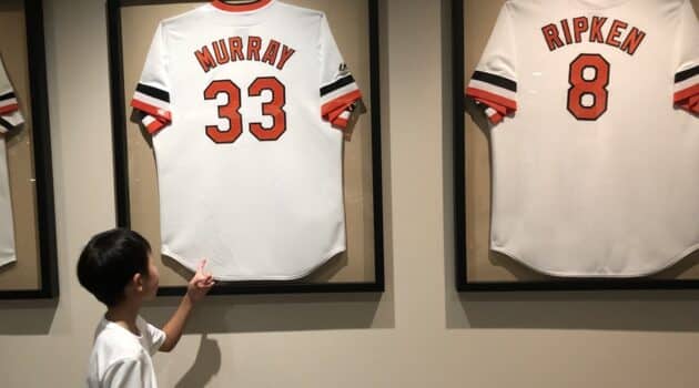 Child points to Murray and Ripken jerseys framed on the wall