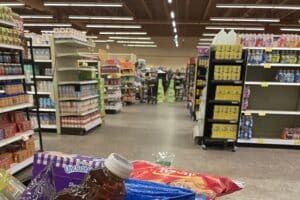 Grocery store with caution signs in the background where a spill is being cleaned up