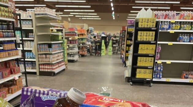 Grocery store with caution signs in the background where a spill is being cleaned up