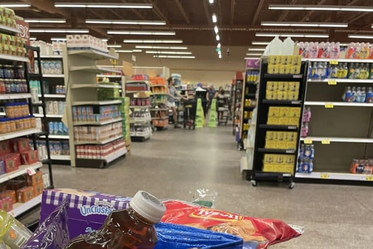 Grocery store with caution signs in the background where a spill is being cleaned up