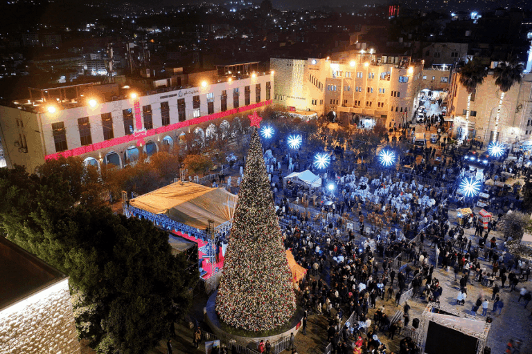 Palestinians attending a Christmas tree lighting in Manger Square outside the Church of the Nativity in Bethlehem