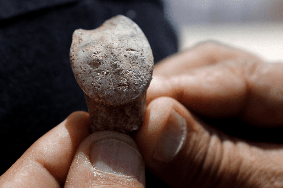 A man in Motza, Israel, holds a human-face figurine