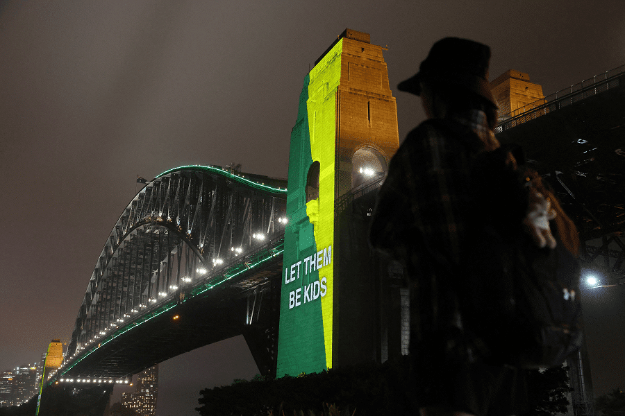 A message the reading "Let them be kids" is projected onto the Sydney Harbor Bridge