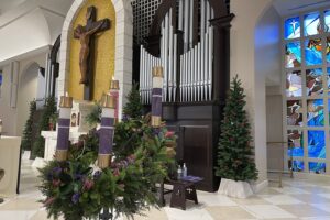 Four candles lit on Advent wreath on the altar in a church