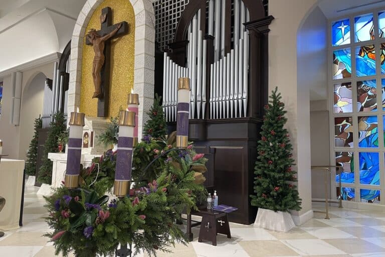 Four candles lit on Advent wreath on the altar in a church