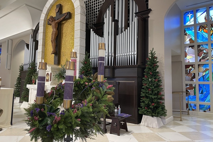 Four candles lit on Advent wreath on the altar in a church