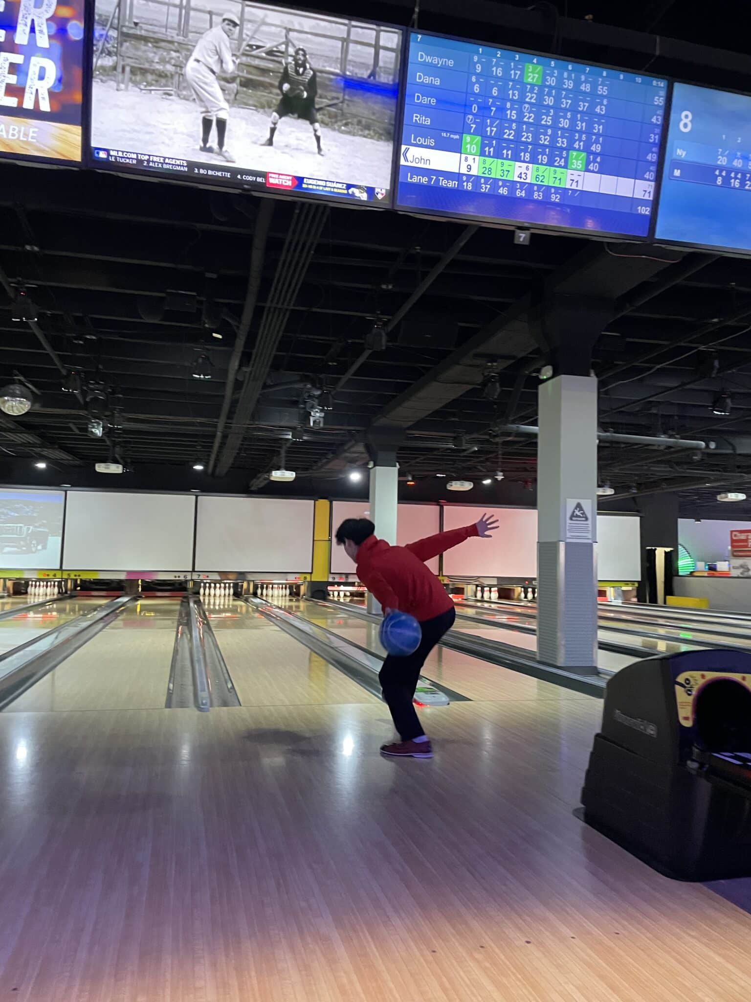 Man seen bowling from behind, about to roll ball down the alley