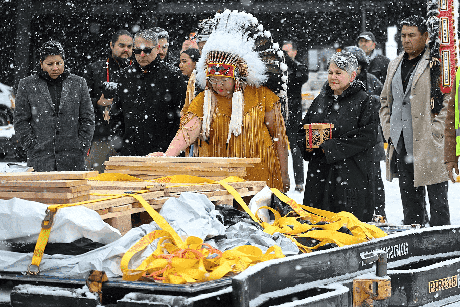 National Chief of the Assembly of First Nations Cindy Woodhouse Nepinak places her hand on Indigenous and cultural artifacts