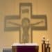 The shadow of a crucifix is shown on the wall of a chapel