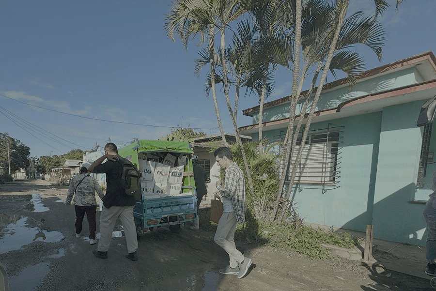 Catholic volunteers load a three-wheeled car with donations in Velasco, Cuba