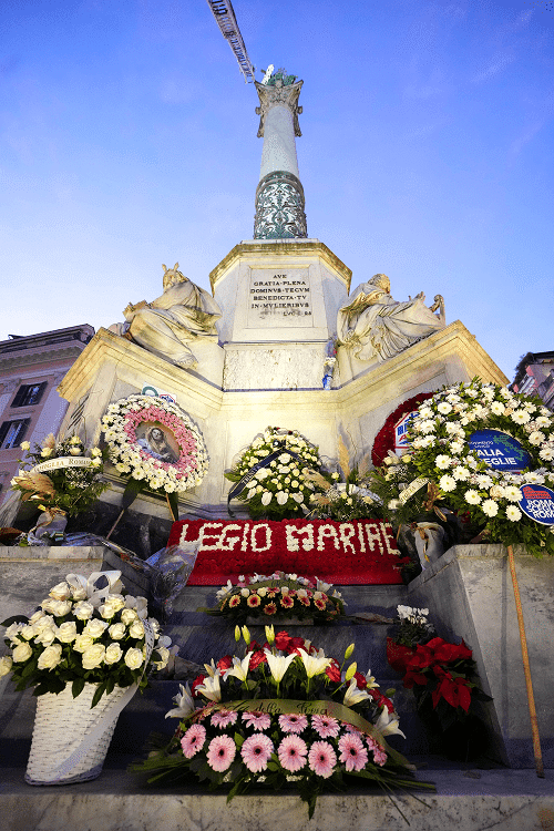 Floral arrangements surround the base of the Column of the Immaculate Conception