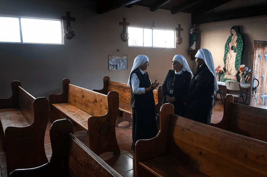 Members of the Eudist Servants of the 11th Hour, chat inside the Catholic chapel