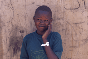 Moltazem Mohamed, 10, a Sudanese refugee boy from al-Fashir, poses at the Tine transit refugee camp