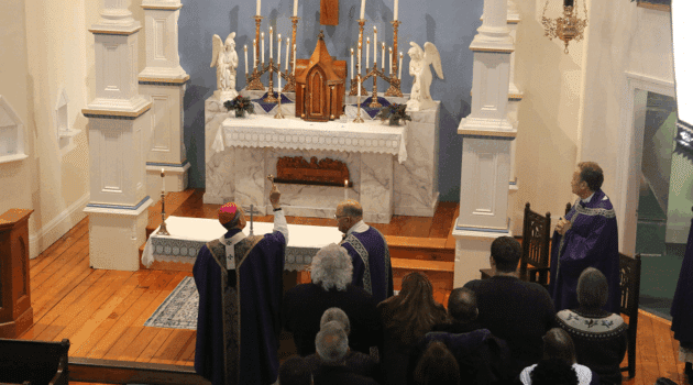 Archbishop William E. Lori sprinkles holy water on the restored historic church at St. Joseph on Carrollton Manor