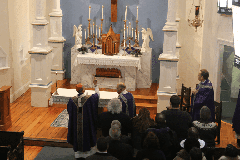 Archbishop William E. Lori sprinkles holy water on the restored historic church at St. Joseph on Carrollton Manor