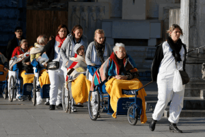 Caregivers push the sick and disabled at the Shrine of Our Lady of Lourdes