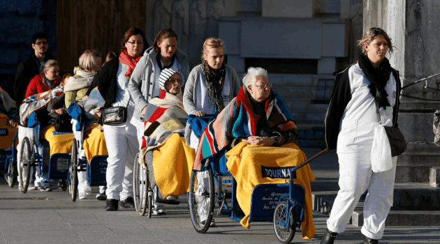 Caregivers push the sick and disabled at the Shrine of Our Lady of Lourdes