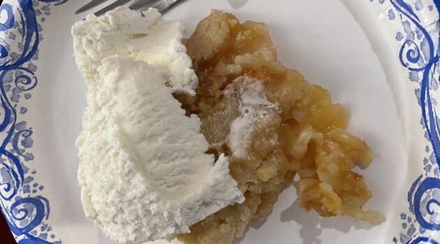 Apple crisp with vanilla ice cream on a paper plate