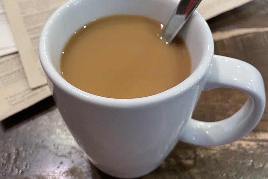 White mug of coffee on a table in a restaurant