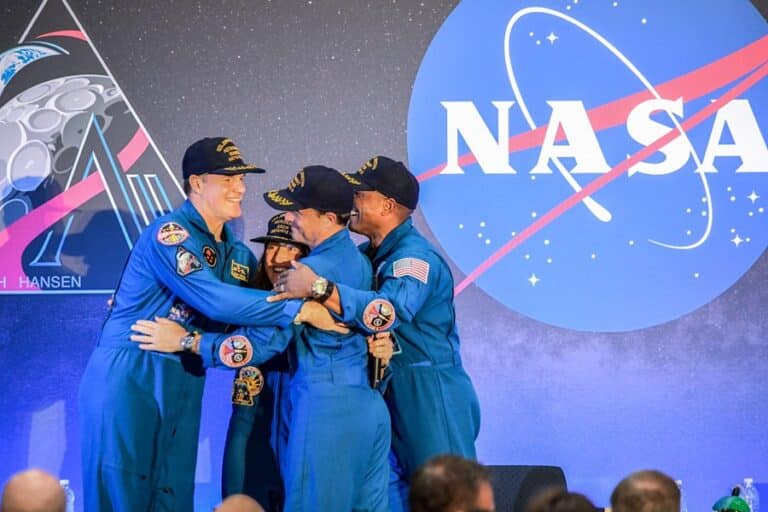 The four astronauts hug after returning from their trip on Artemis II