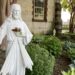 White statue of Jesus stands in a garden outside a church
