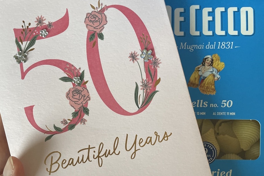 Birthday card that says 50 beautiful years on it with a box of pasta in the background
