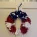 Red, white, and blue wreath hanging on a white door