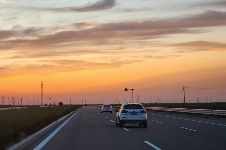 A car drives on a road at sunset