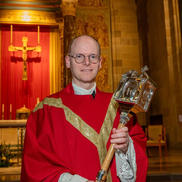 Father Gould takes charge with encouragement, kind words and mace in hand
